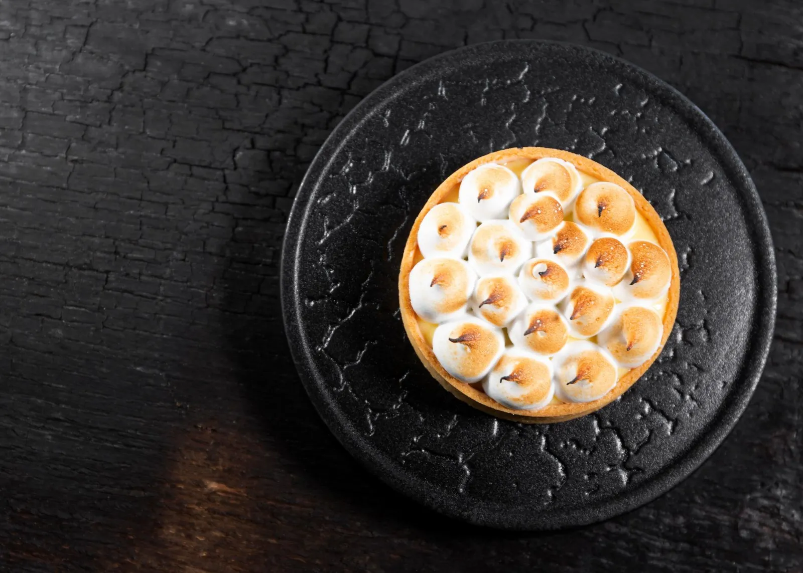 Dessert met meringue op een zwart bord
